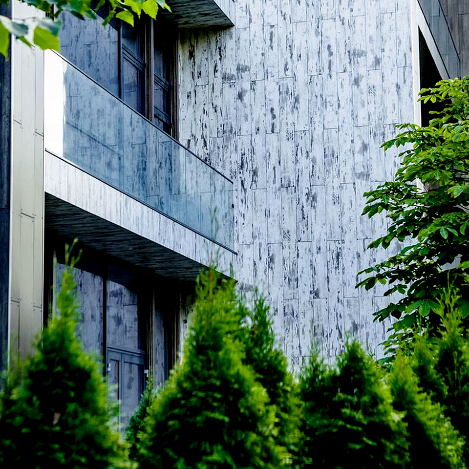 Стеклянные фасады дополнены отделкой из теплостойких панелей в бронзовых и серебристых тонах от австрийской компании FunderMax. Фото: Villagio Estate