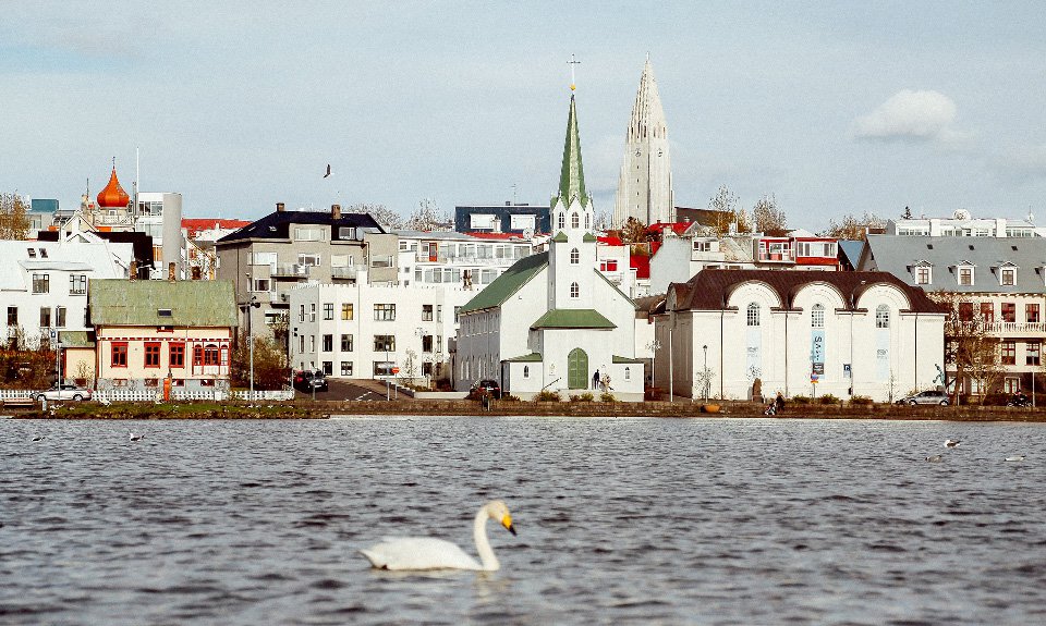 Главное здание Национальной галереи Исландии (справа от церкви) стоит на берегу озера Тьернин в самом центре Рейкьявика.  Фото: Evelyn Paris/Unsplash