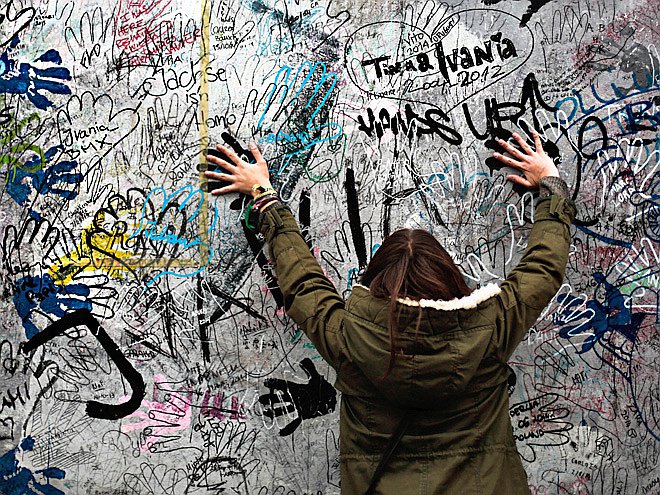 Девушка на фоне крупнейшей (1,3 км) сохранившейся части Берлинской стены — с 1990 г. на ней размещается галерея под открытым небом East Side Gallery. Фото: AP Photo/Markus Schreiber