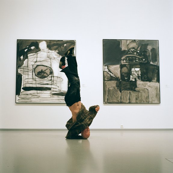 Евгений Музалевский на фоне своих работ. Персональная выставка «Монохром, с мамой за спиной» в МАММ (2024). Фото: Аlina Pinsky Gallery