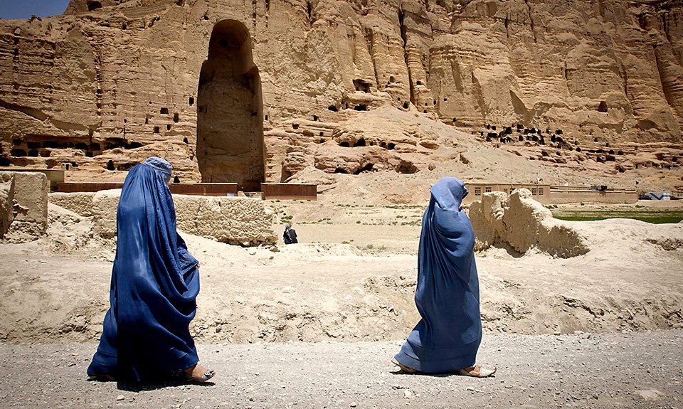 Женщины проходят мимо огромной впадины в провинции Бамиан, где раньше стояла одна из статуй Будды, которую уничтожили в 2001 году. Фото: Legio