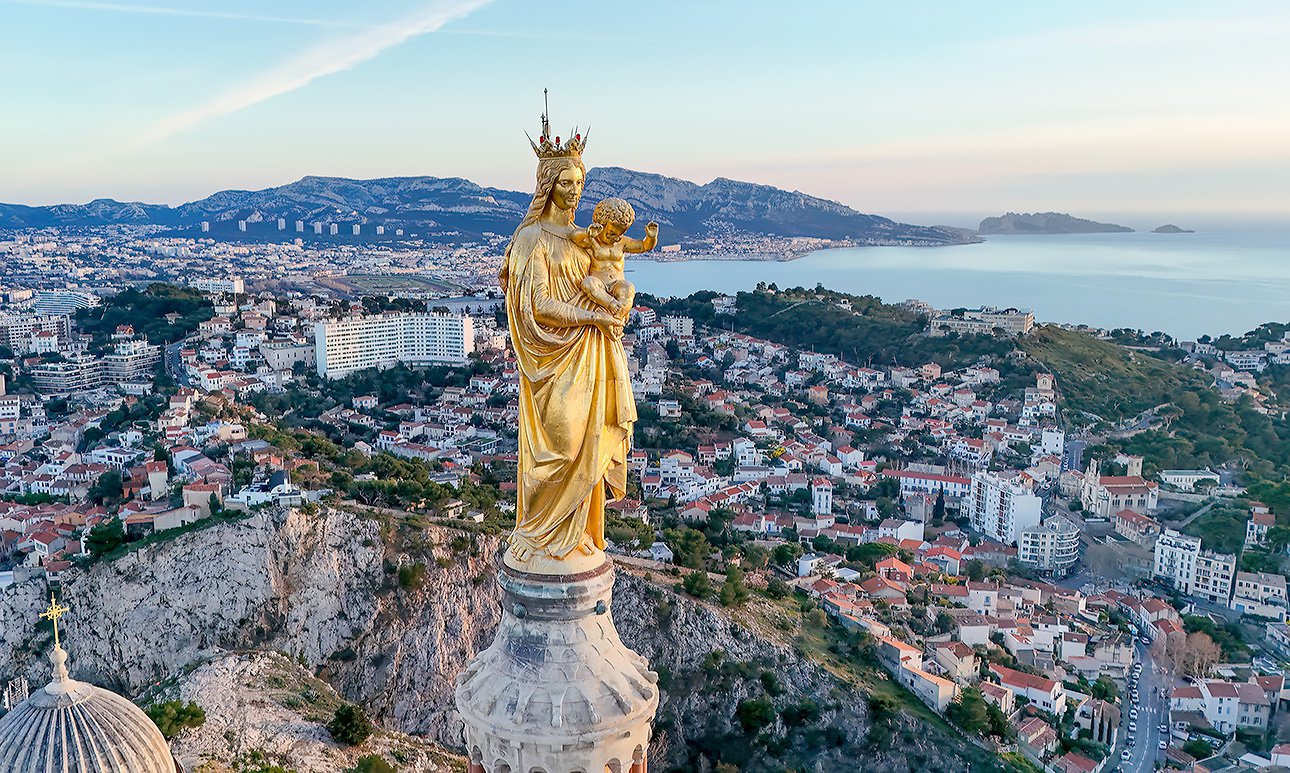Медная статуя Мадонны с Младенцем венчает колокольню базилики Нотр-Дам де ла Гард в Марселе. Местные жители называют ее La Bonne Mère («Добрая Мать») и верят, что она защищает горожан. Фото: Giles Laurent/Wikimedia