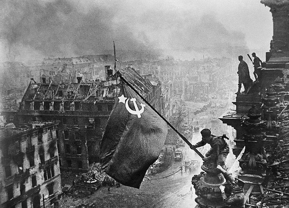 Германия. 2 мая 1945 г. Бойцы 8-й гвардейской армии Алексей Ковалев (со знаменем), Абдулхаким Исмаилов и Леонид Горычев водружают Знамя Победы над Рейхстагом. Фото: Халдей Евгений/Фотохроника ТАСС