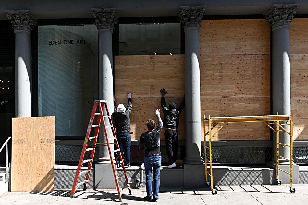 Рабочие заколачивают окна художественной галереи в Нью-Йорке в апреле 2020 г. Фото: Erik Pendzich/Shutterstock